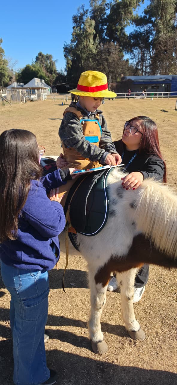 Actividad asistida con un caballo en Ciudad Inclusiva ZooCeo, con un niño acompañado por dos adultas